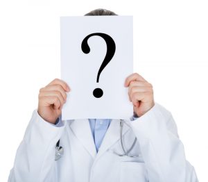 Doctor holding a question mark sign in front of face