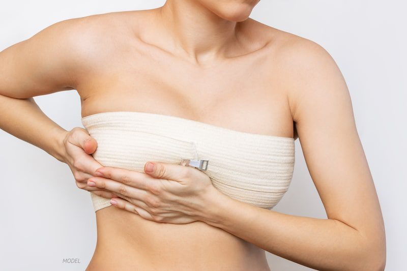 Woman with post-op bandages around her breasts